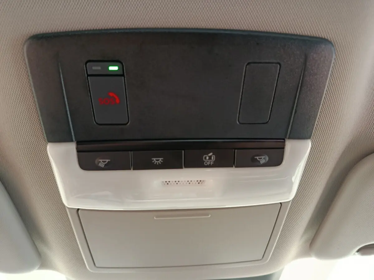 Vue en gros plan du panneau de commandes au plafond intérieur du Nissan Qashqai e-Power blanc, avec bouton SOS et éclairage.