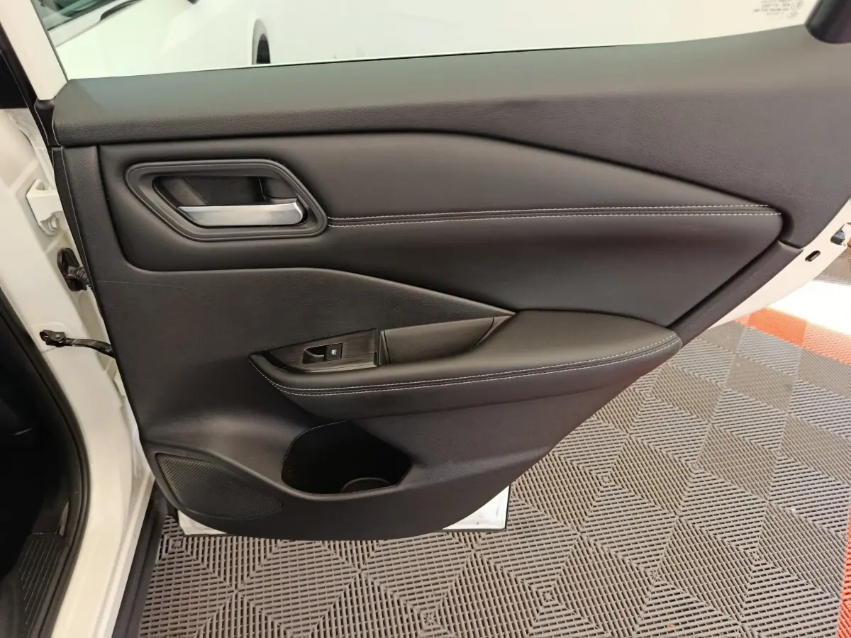 Vue intérieure de la porte avant gauche noire du Nissan Qashqai e-Power 2024 avec poignée et commande de fenêtre.