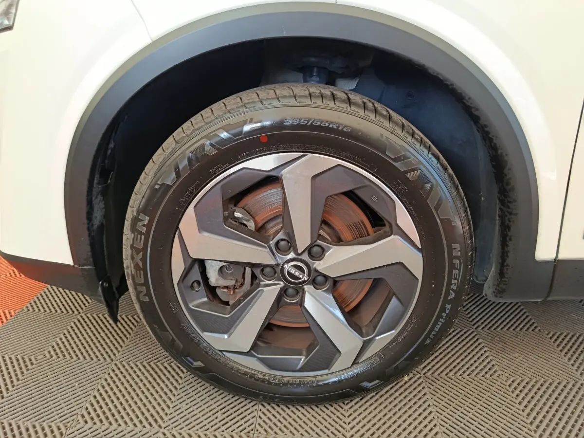 Gros plan sur la roue avant droite du Nissan Qashqai blanc 2024 avec jante alliage et pneu Nexen.