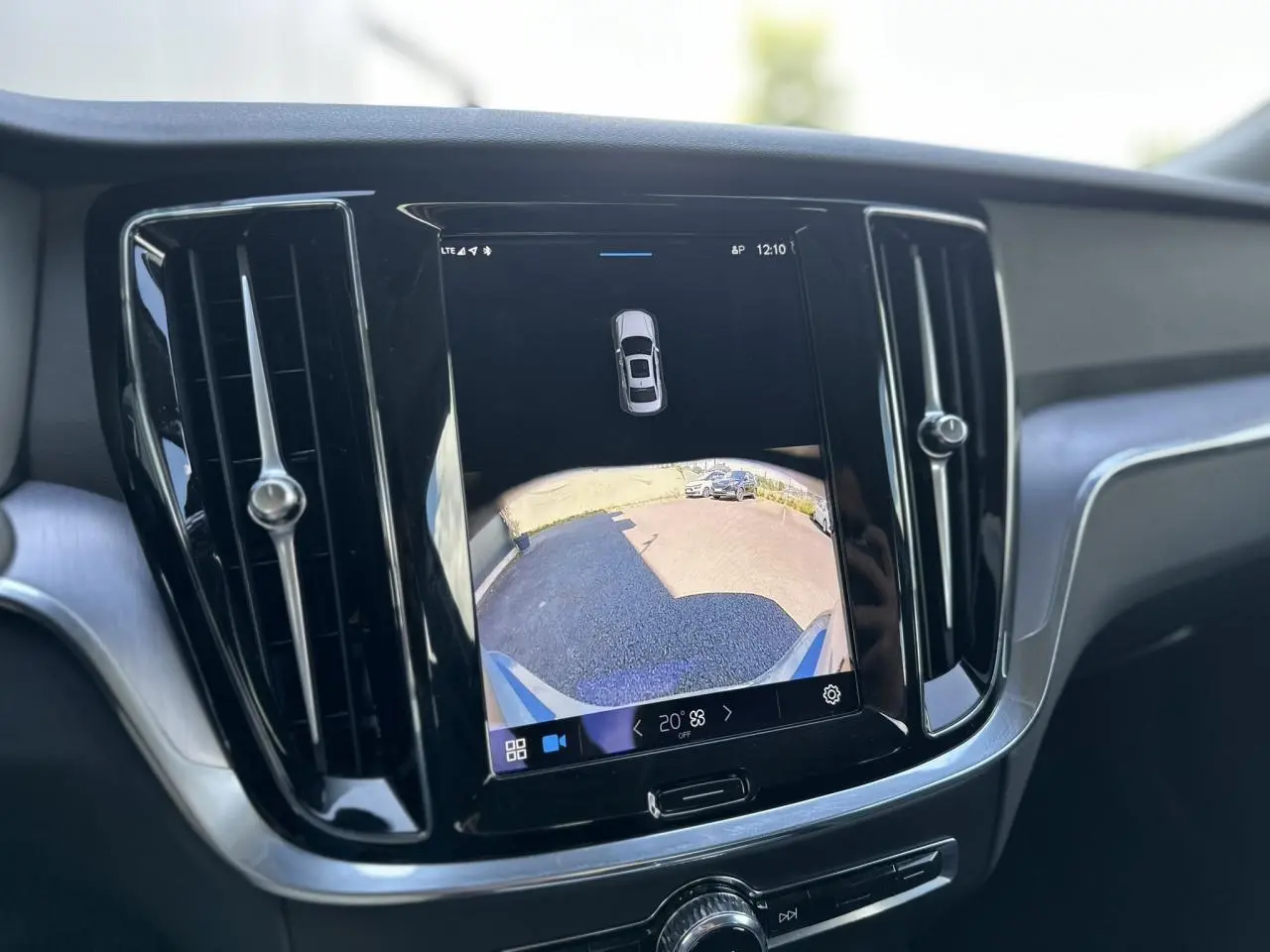 Écran tactile central affichant la caméra de recul du Volvo S60 gris Thunder, entouré de grilles d'aération verticales noires.