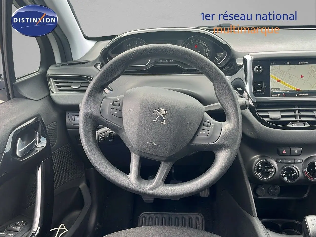 Vue intérieure centrée sur le volant Peugeot 208 2020, tableau de bord et écran tactile avec navigation visible.