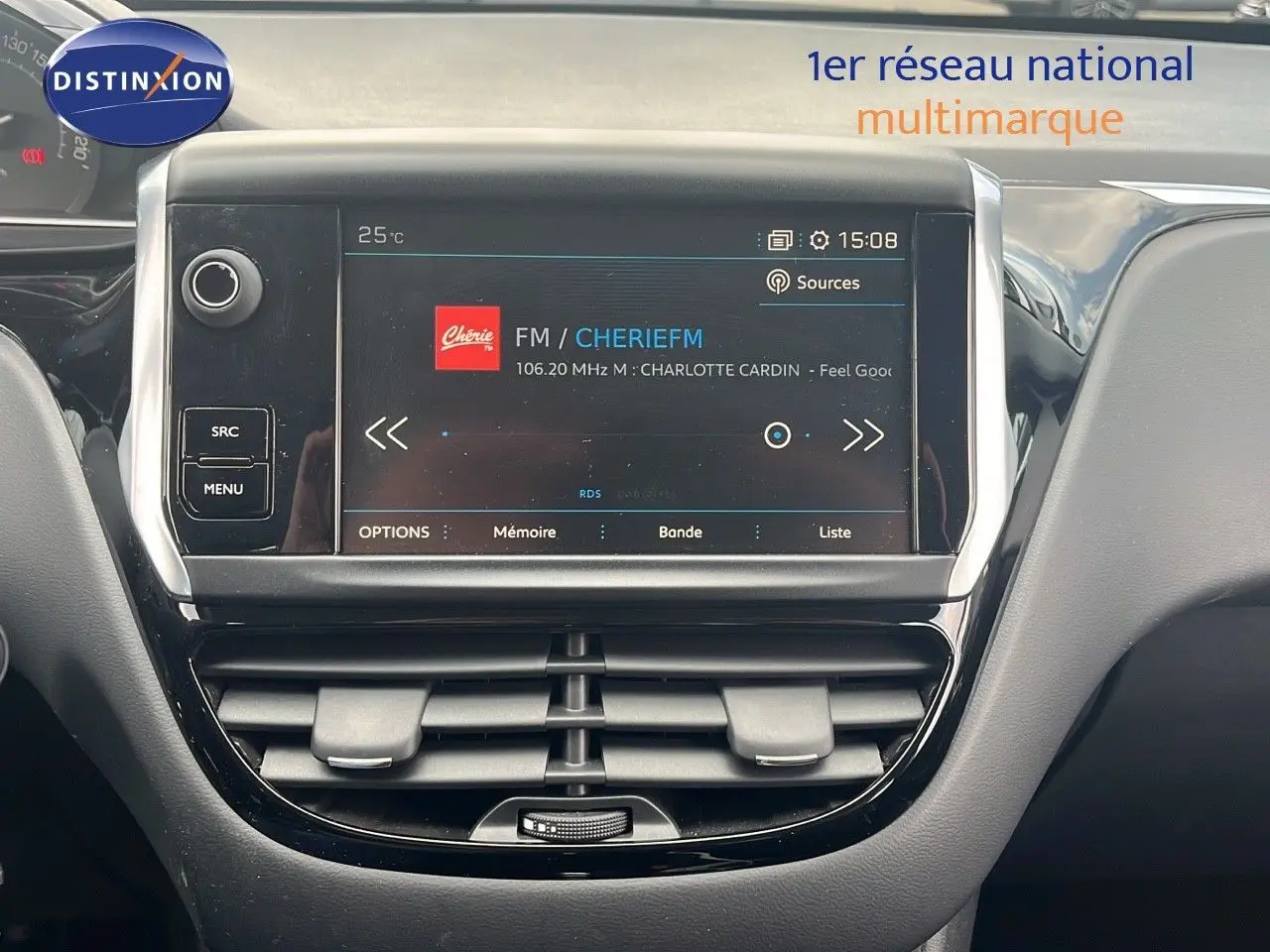 Vue rapprochée de l'écran multimédia central du Peugeot 208 blanc banquise, affichant une radio FM.