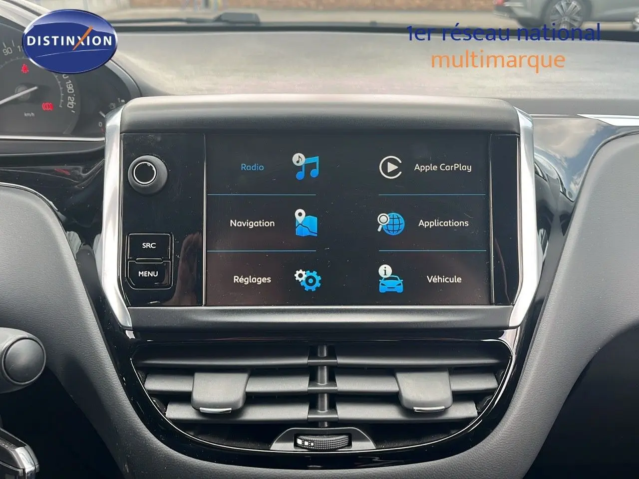 Écran tactile central du tableau de bord du Peugeot 208 blanc banquise, affichant les options multimédia et navigation.