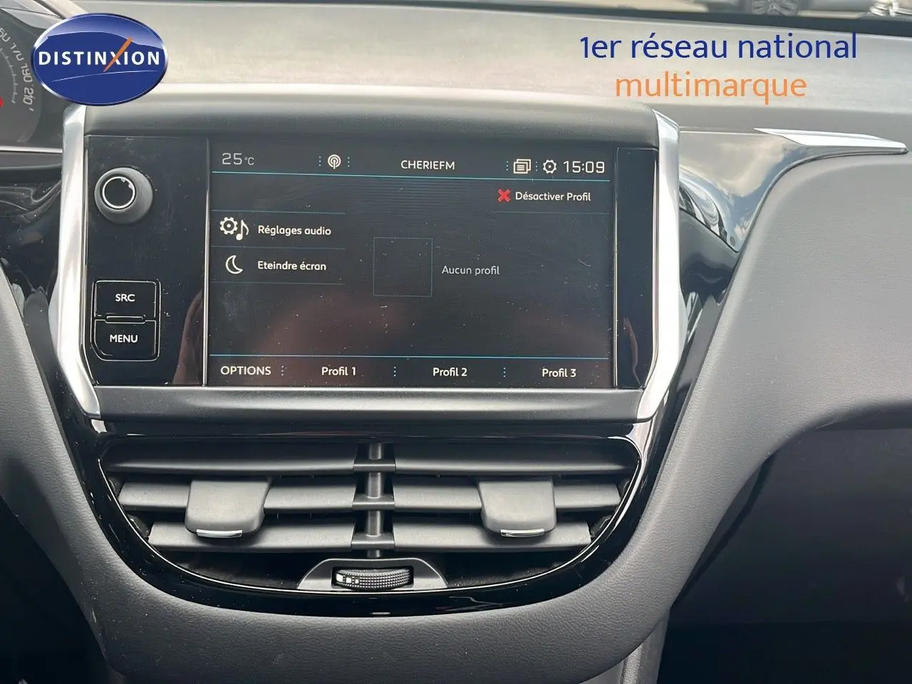 Vue rapprochée de l'écran tactile central et des aérateurs du tableau de bord de la Peugeot 208 blanche banquise 2020.