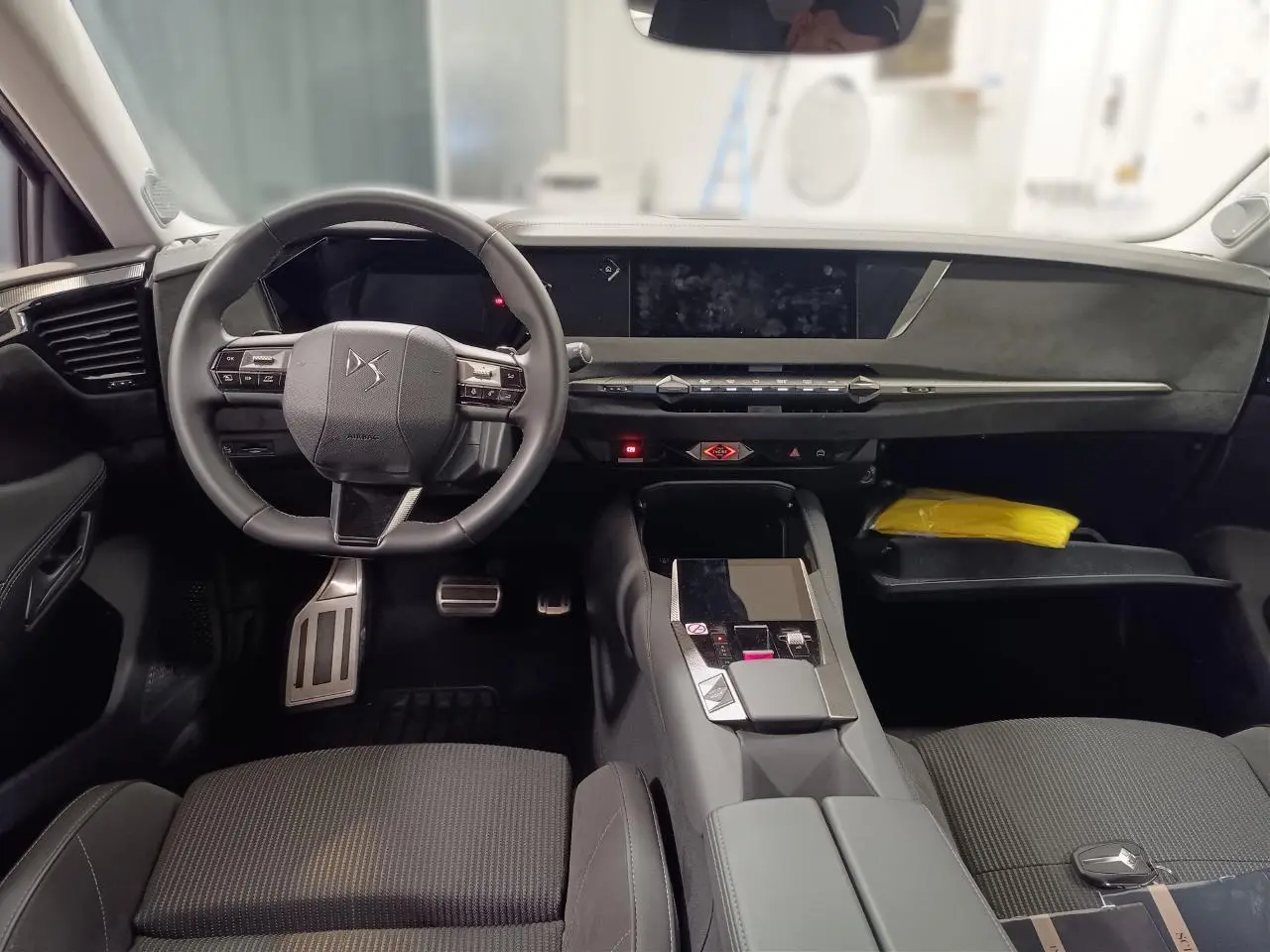Intérieur du DS4 2025 vu de face, tableau de bord et volant cuir noir avec console centrale moderne.