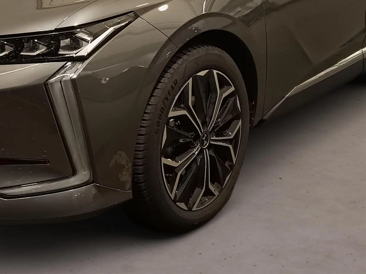 Gros plan sur la roue avant droite et le passage de roue d'une DS4 gris Platinium avec feux LED verticaux distinctifs.