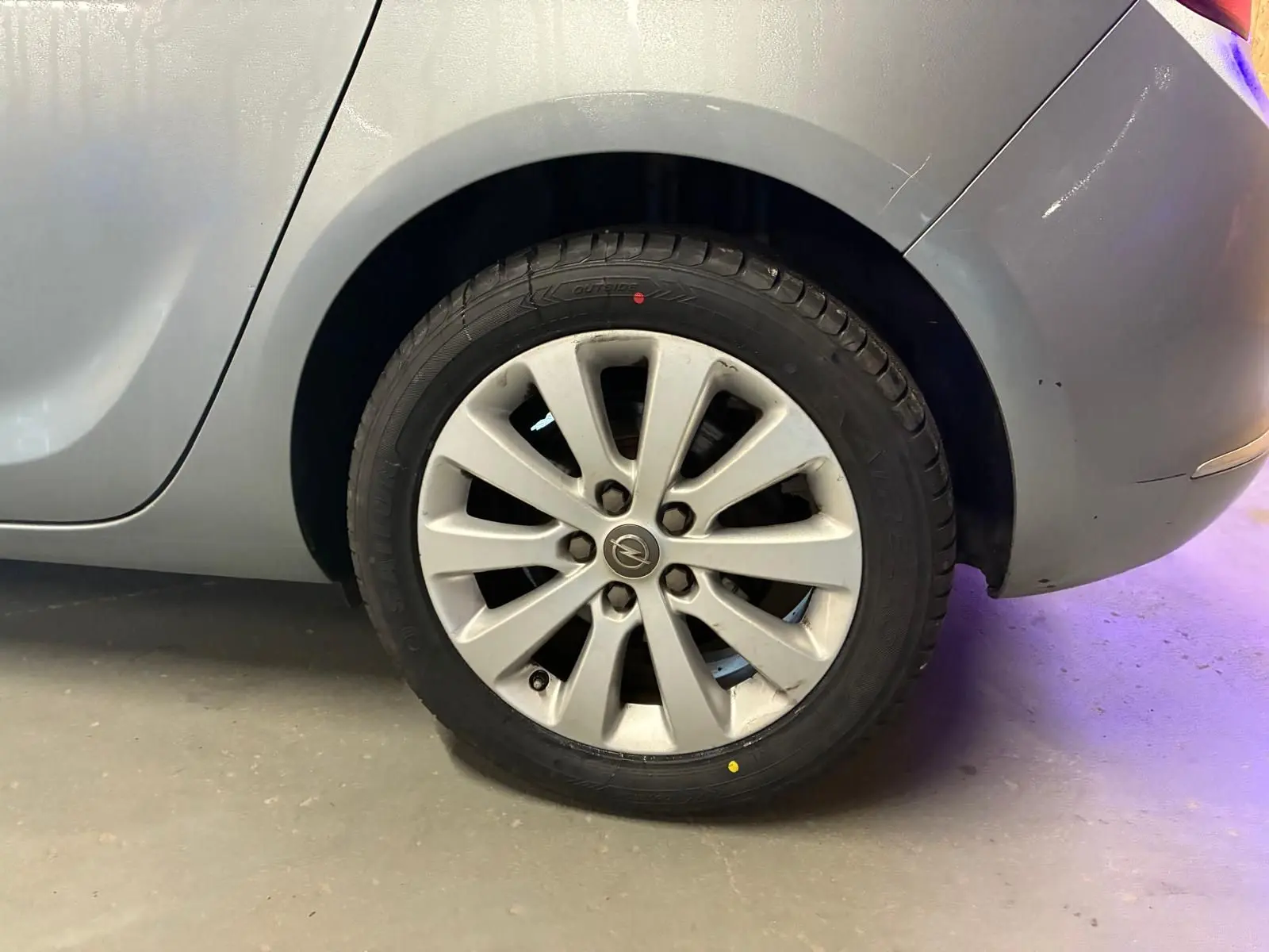 Gros plan sur la roue arrière droite grise d'une Opel Astra 1.6 CDTI 110 diesel de 2015 avec jante alliage.