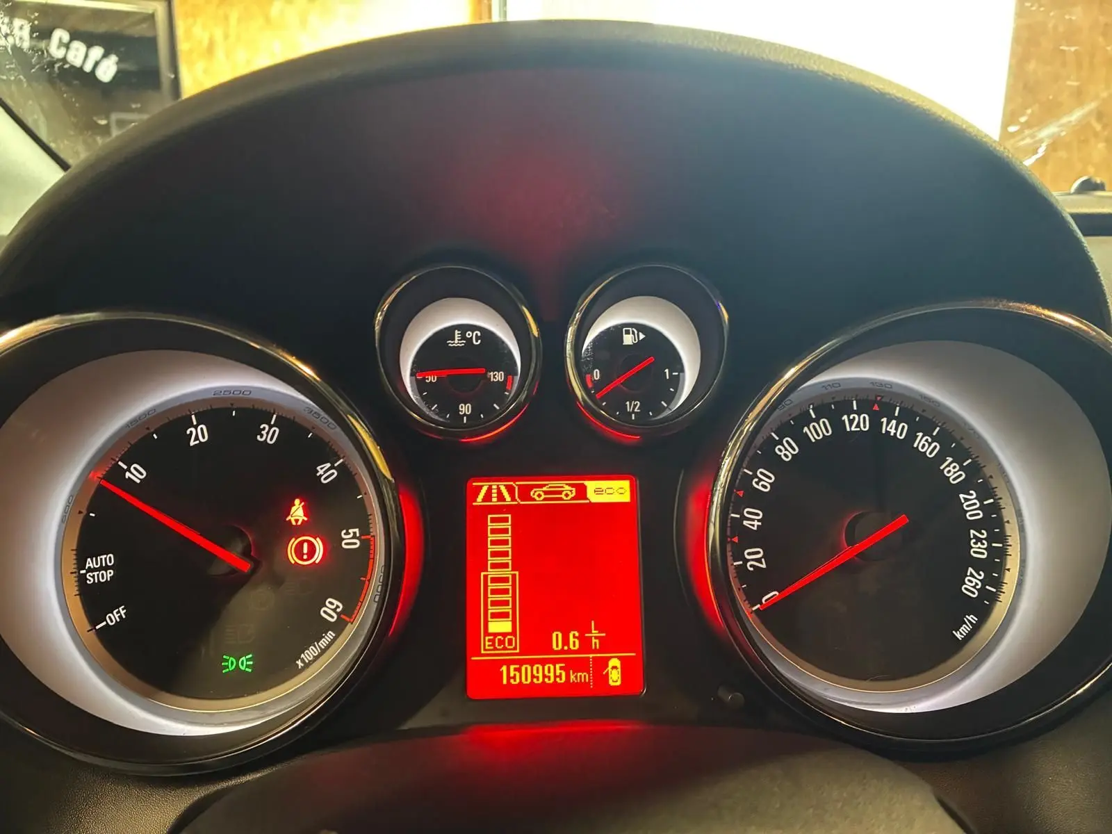 Tableau de bord d'Opel Astra 1.6 CDTI 2015 avec compte-tours, vitesse, jauges et écran central rouge allumé.