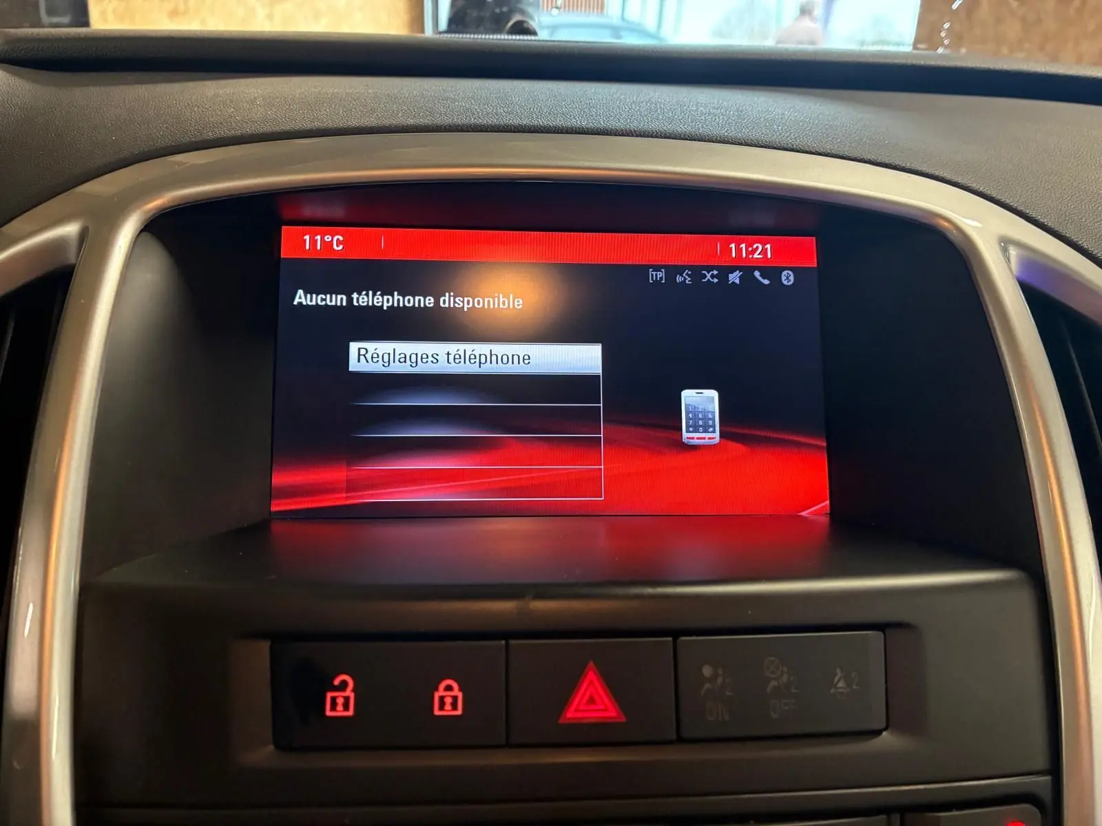 Écran central de l’Opel Astra gris 2015 affichant le menu réglages téléphone avec icônes rouges de verrouillage.