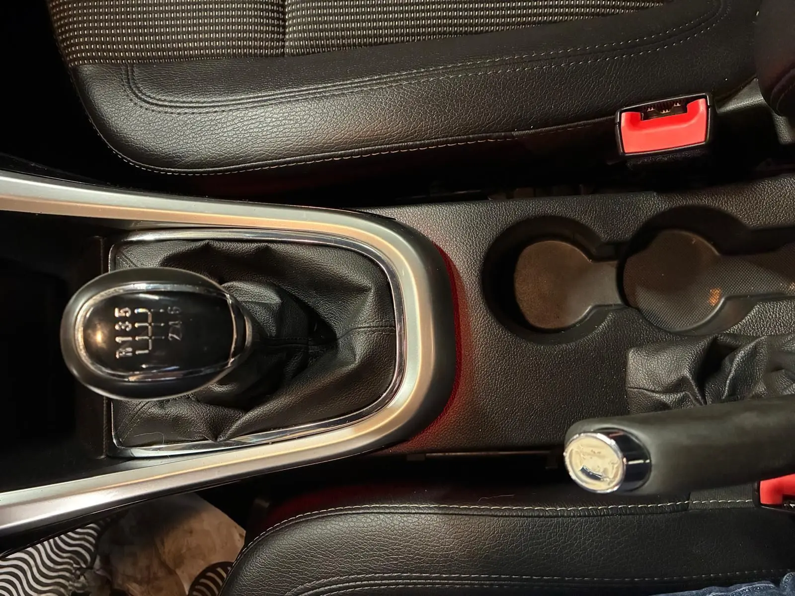 Vue rapprochée de la console centrale de l’Opel Astra gris, mettant en valeur le levier de vitesse manuel et le frein à main noir.