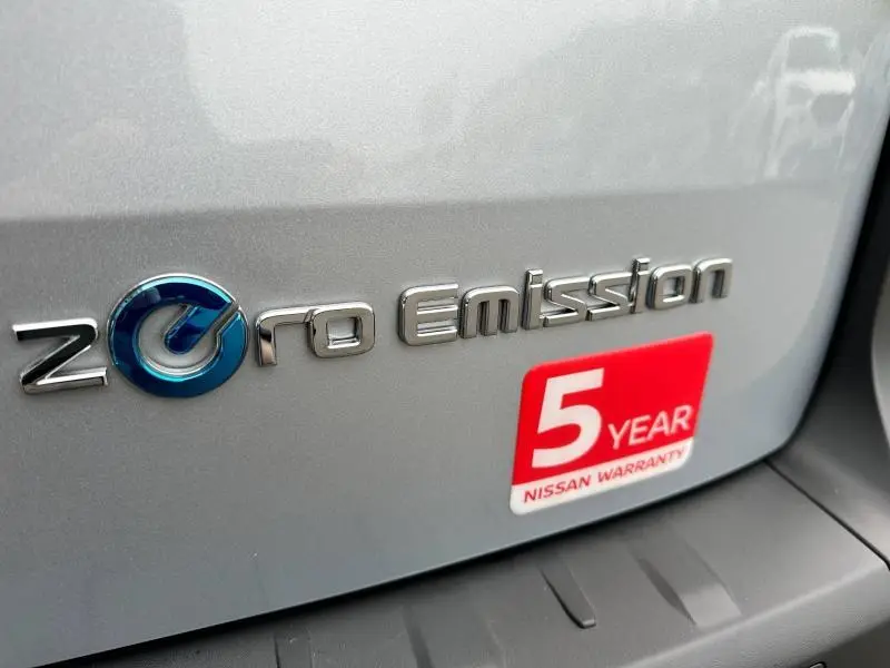 Gros plan sur l’inscription "Zero Emission" et l’autocollant de garantie 5 ans sur la carrosserie grise du Nissan Townstar électrique.