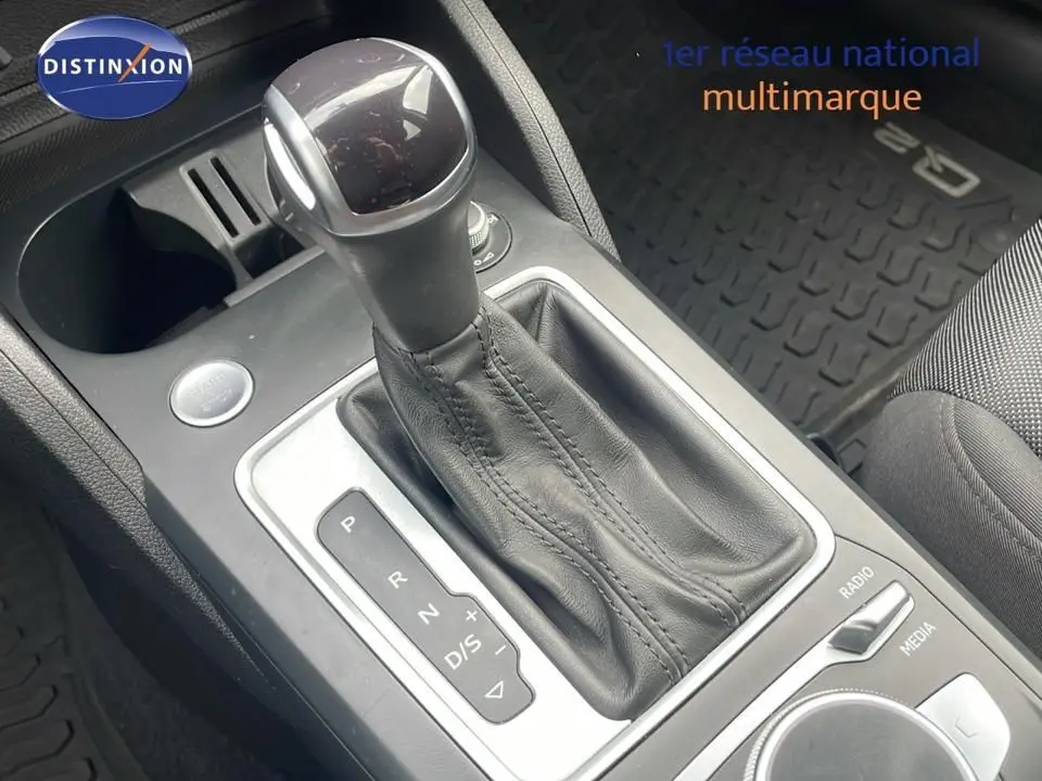 Le levier de vitesses automatique en cuir noir de l'Audi Q2 35 TFSI S-Line vu en gros plan intérieur.