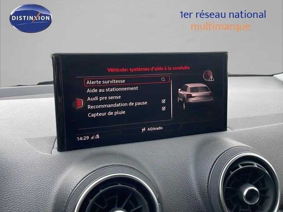 Écran central affichant les aides à la conduite du tableau de bord d'un Audi Q2 noir mito metal de 2023.