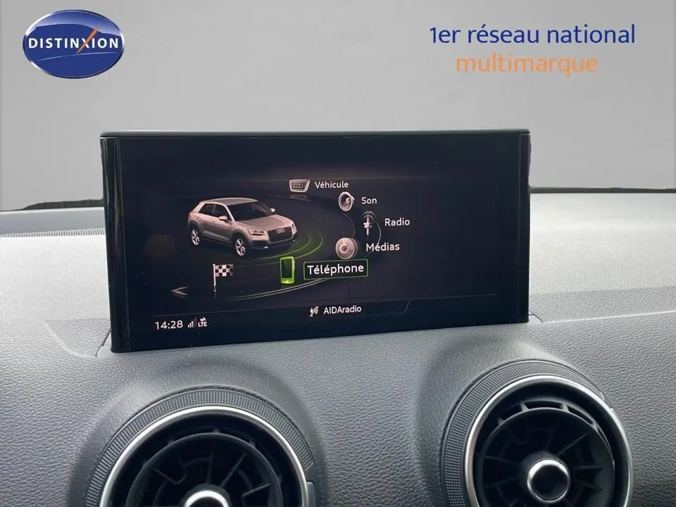 Écran central de l'Audi Q2 35 TFSI S-Line 2023 affichant le menu téléphone, avec aérateurs ronds en avant-plan.