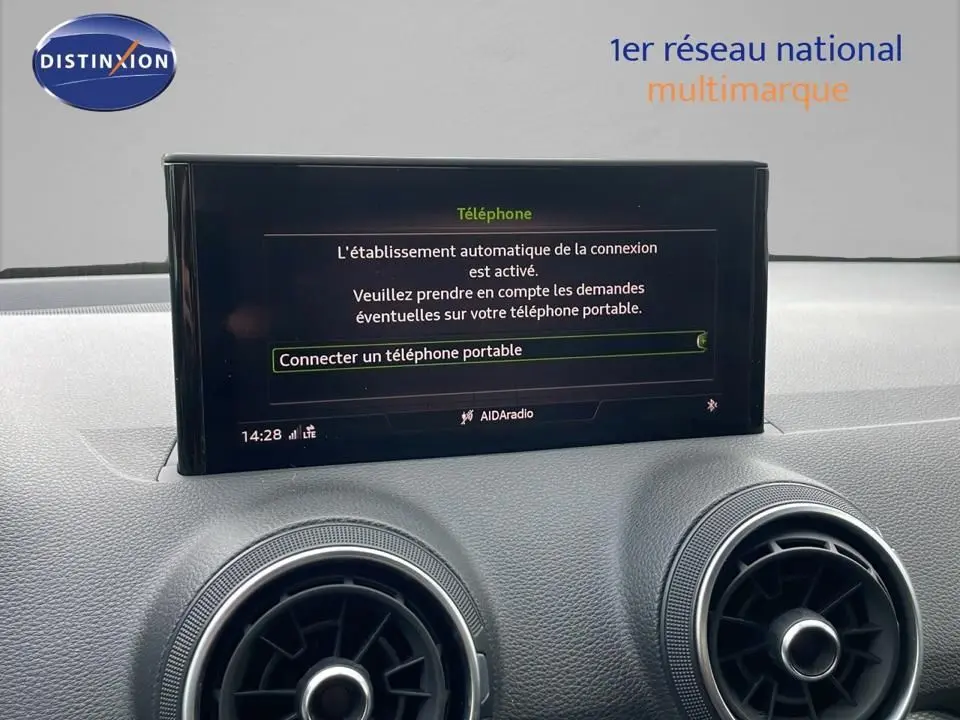 Écran central affichant la connexion Bluetooth dans l'habitacle d'un Audi Q2 noir mito metal, vue intérieure avant.