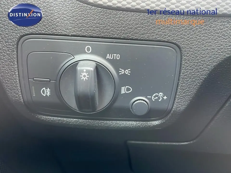 Gros plan sur le bouton de commande des phares dans l'habitacle noir de l'Audi Q2 35 TFSI S-Line 2023.