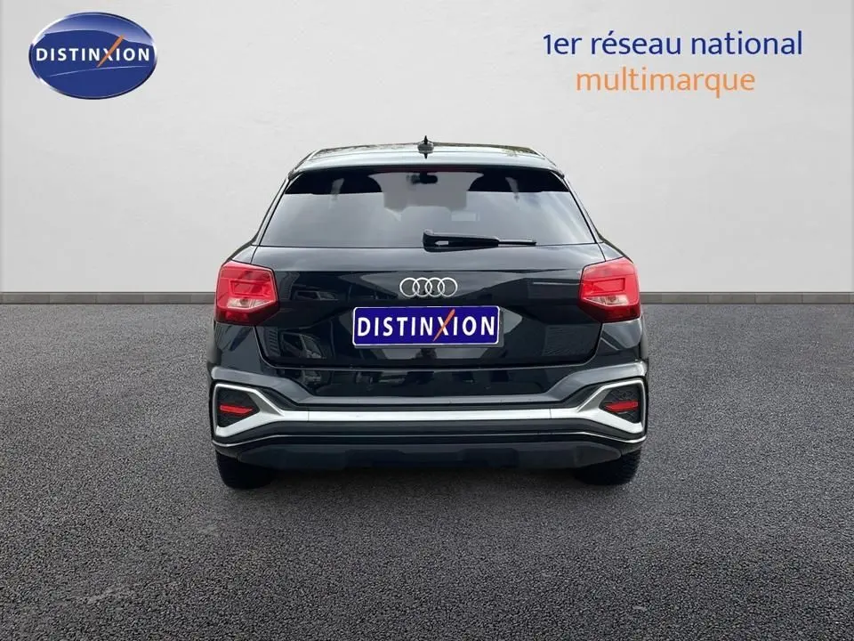 Vue arrière d'un Audi Q2 noir mito metal 2023 avec feux rouges et logo Audi visible sur un fond neutre.