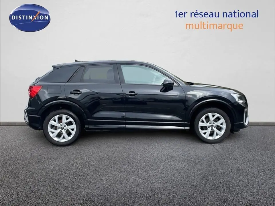 Profil droit d'un Audi Q2 35 TFSI S-Line noir mito metal 2023, avec jantes alliage et lignes épurées.