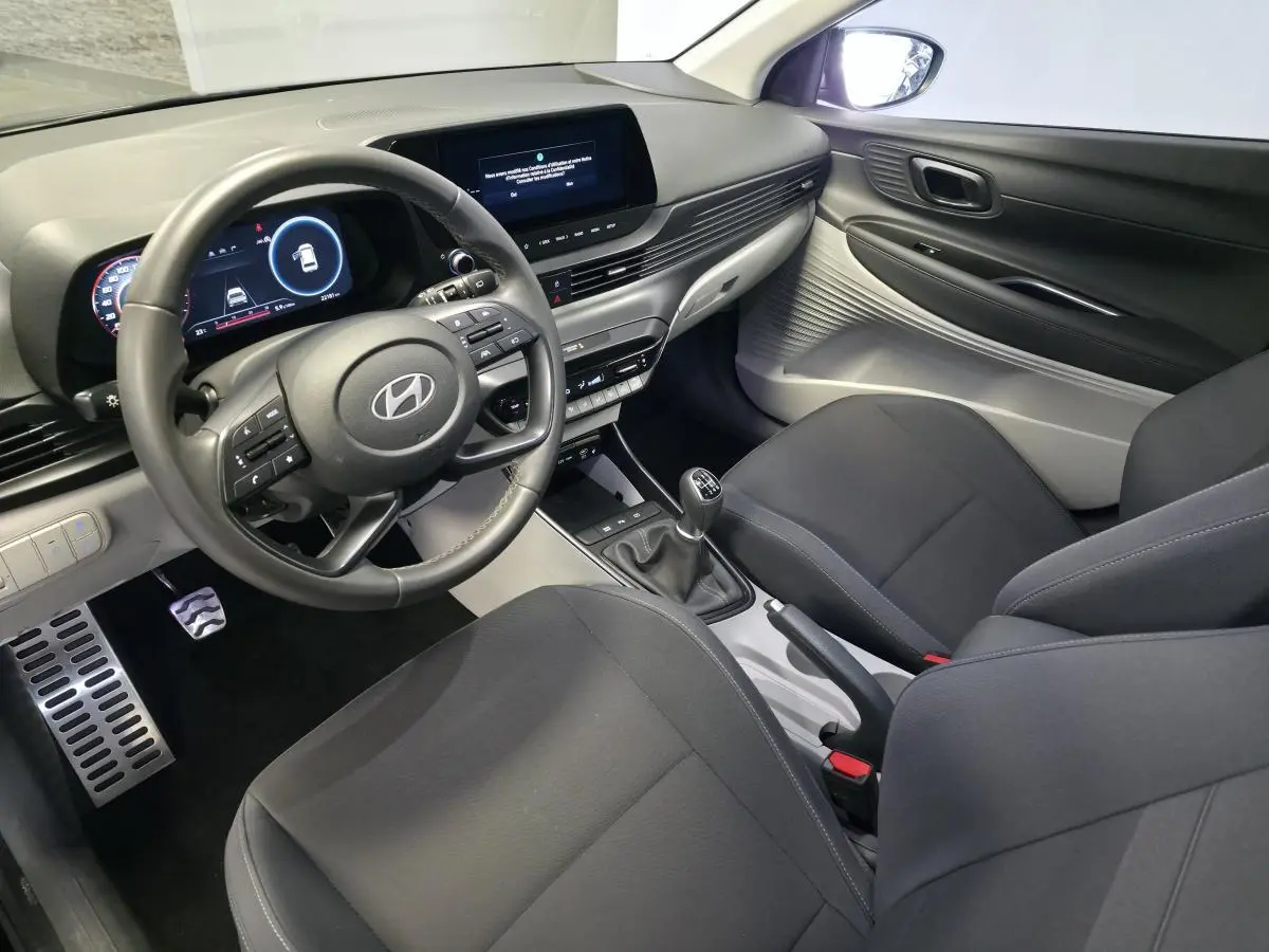 Vue intérieure côté conducteur du Hyundai Bayon 2025, volant cuir, tableau de bord numérique et console centrale grise.