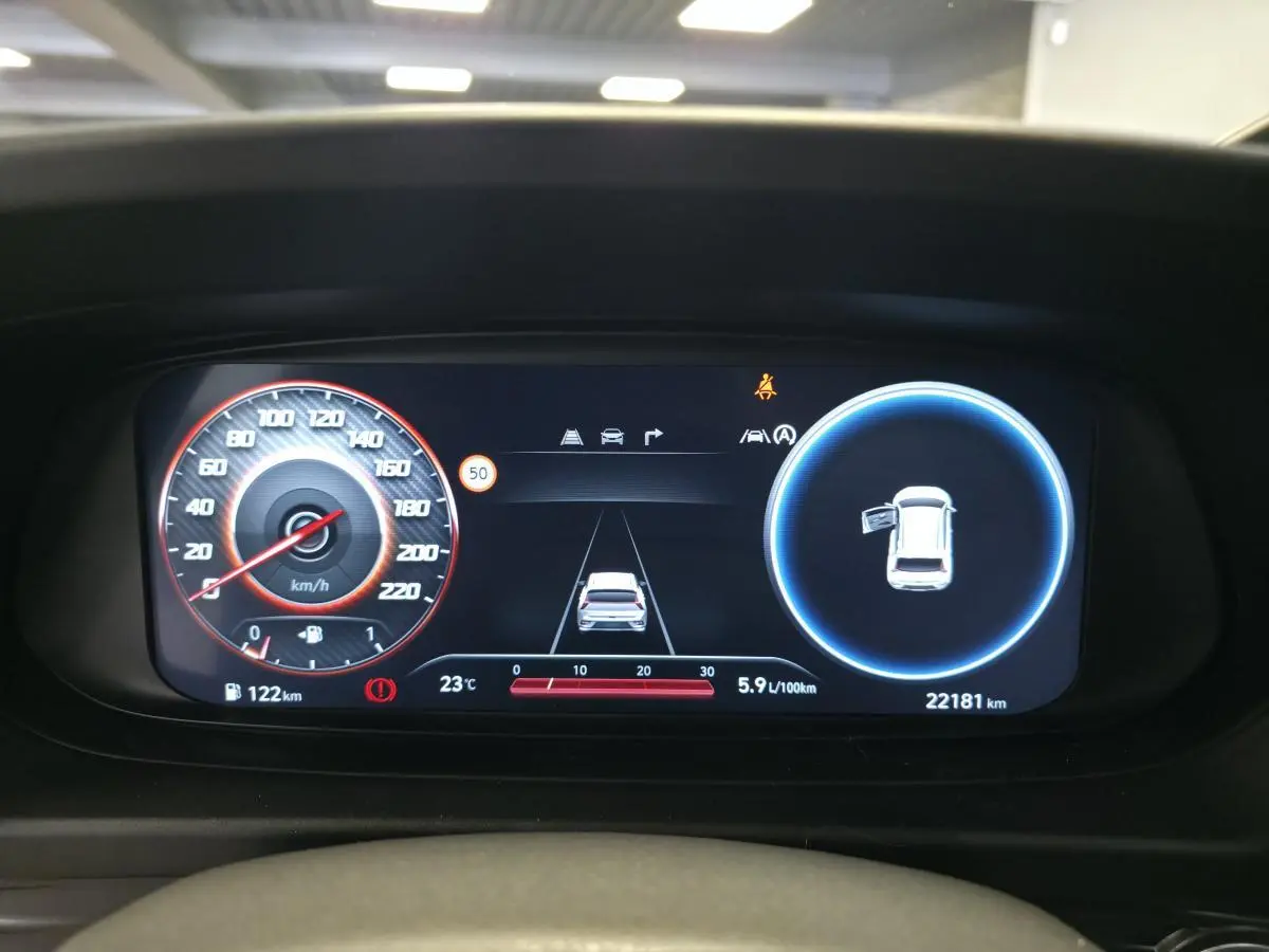 Affichage numérique du tableau de bord du Hyundai Bayon 2025 montrant la vitesse, la consommation et porte avant gauche ouverte.