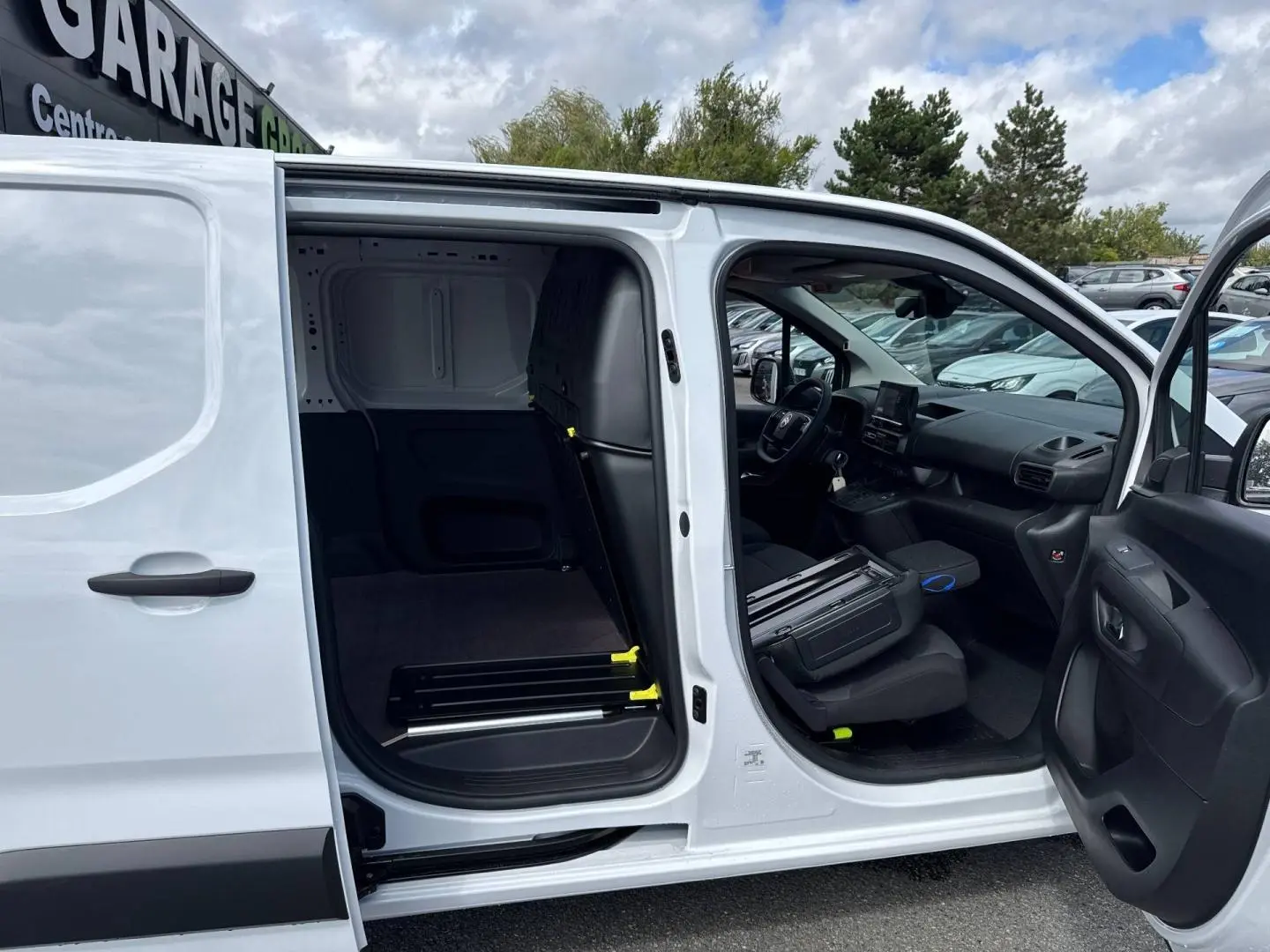Vue latérale droite d’un Citroën Berlingo Fourgon XL blanc Icy avec portes avant et latérale ouvertes, montrant l’intérieur utilitaire.