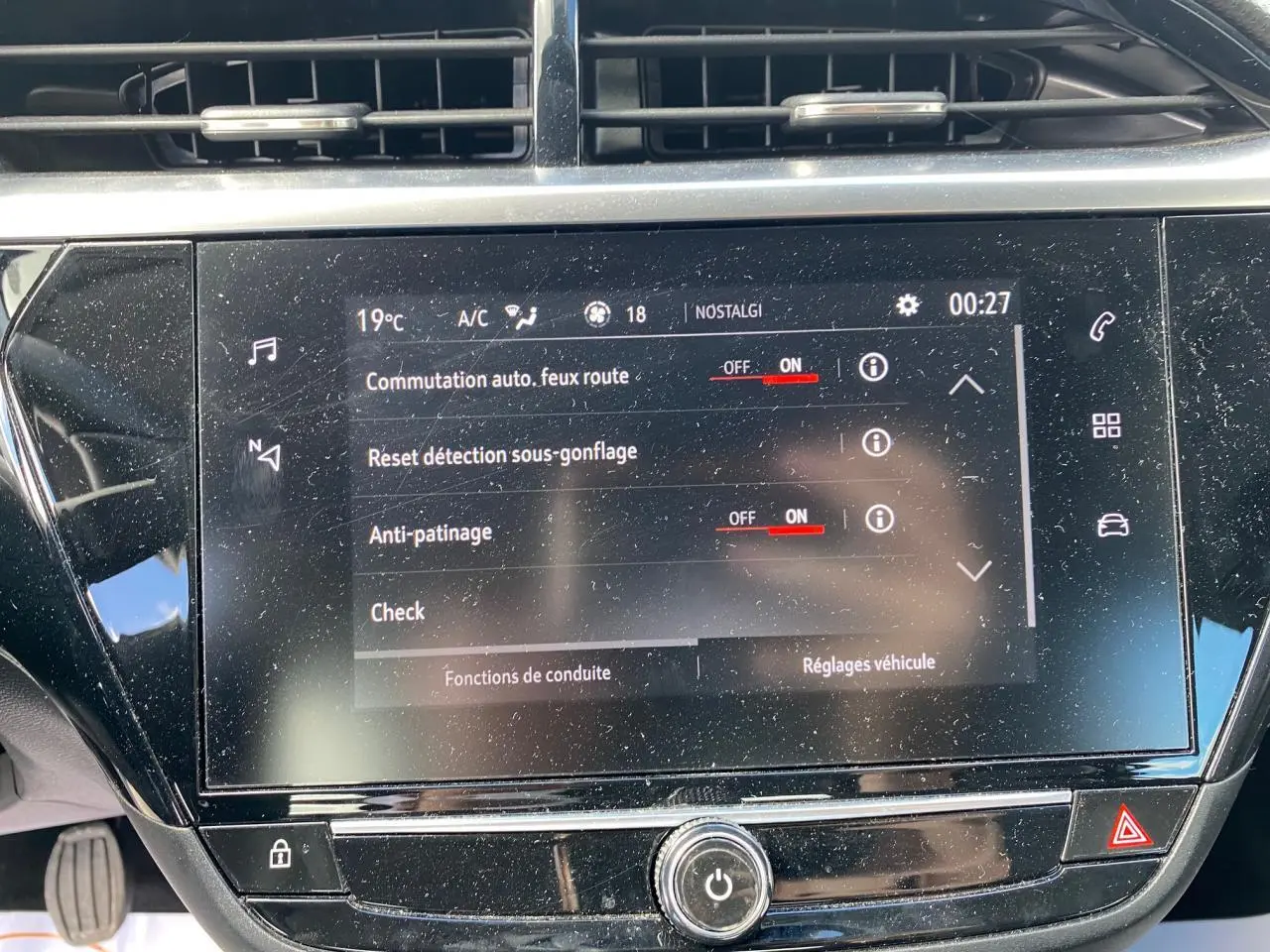 Vue rapprochée du tableau de bord de l'Opel Corsa bleu nautique, mettant en valeur l'écran digital tactile et les commandes tactiles latérales.