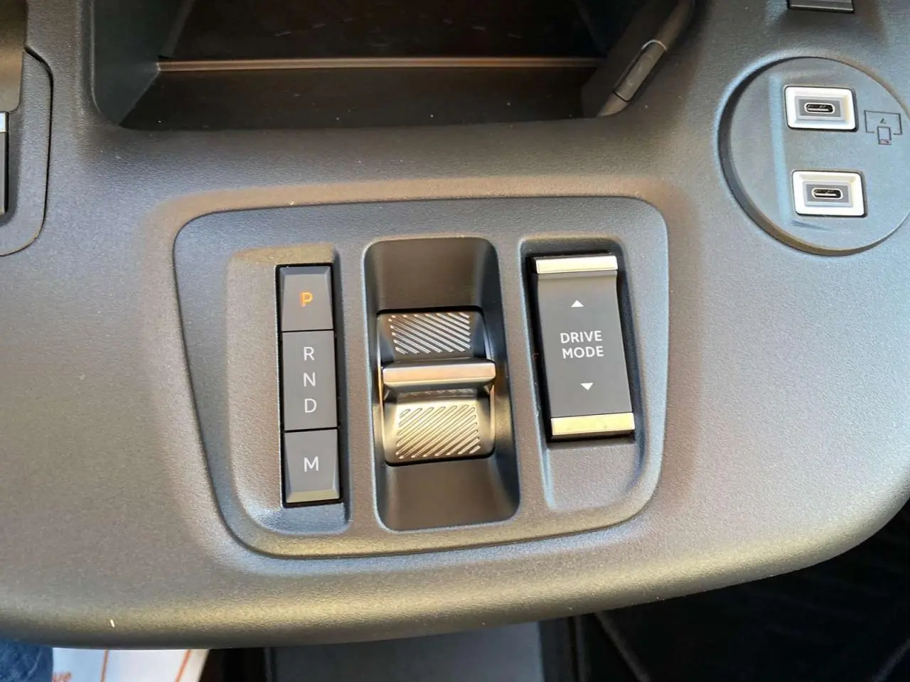 Gros plan sur la console centrale du Citroën Berlingo 2025 montrant la commande de boîte automatique et le bouton Drive Mode.