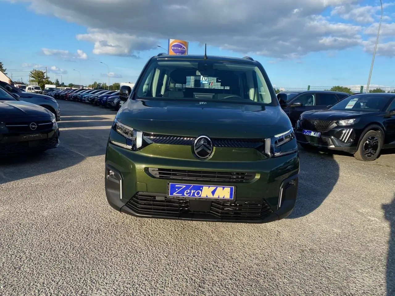 Vue de face du Citroën Berlingo 2025 vert Sirka avec calandre moderne et plaque Zero KM visible.