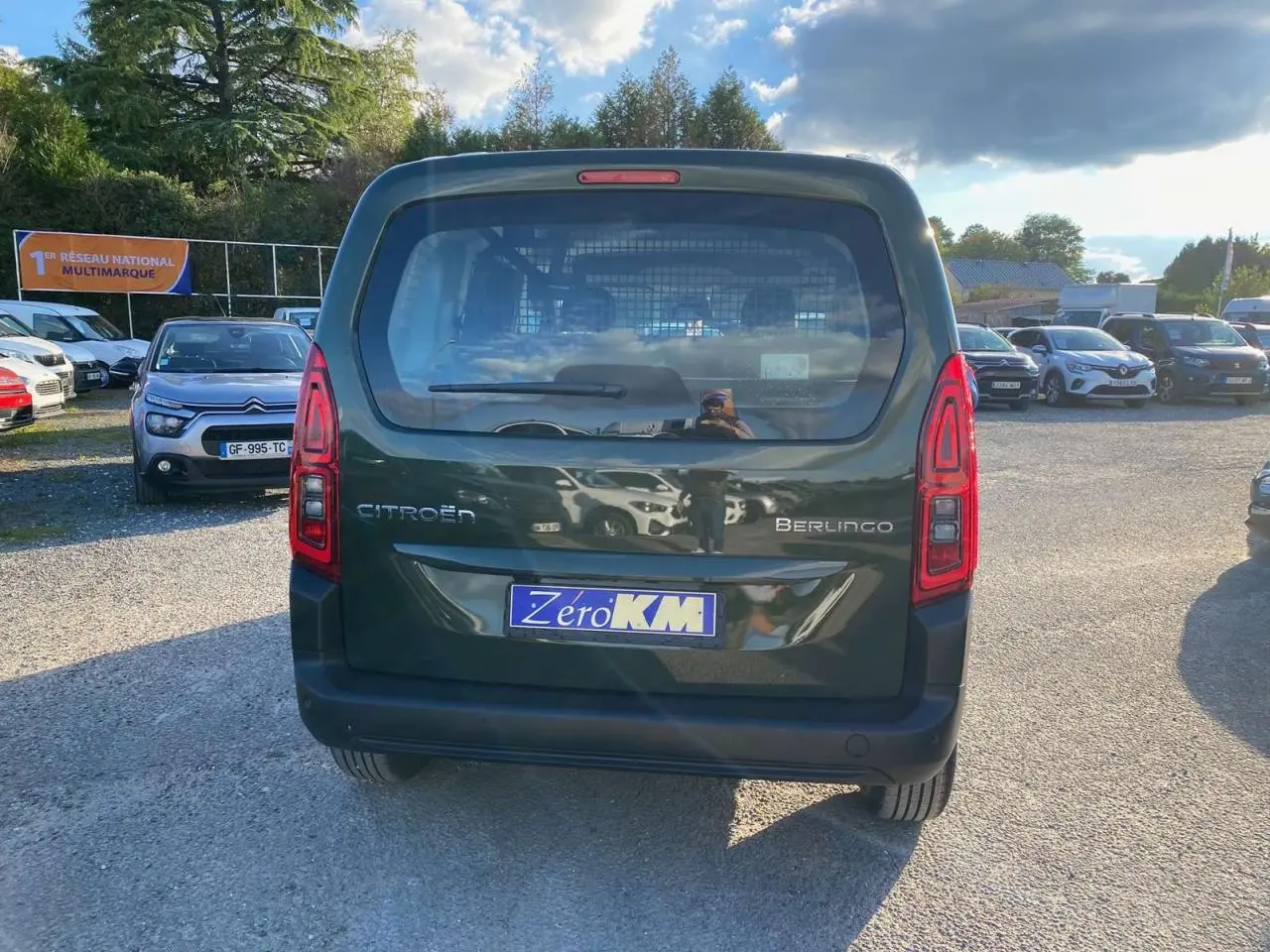 Vue arrière d'un Citroën Berlingo 2025 vert Sirka avec feux rouges allongés et plaque Zéro KM.