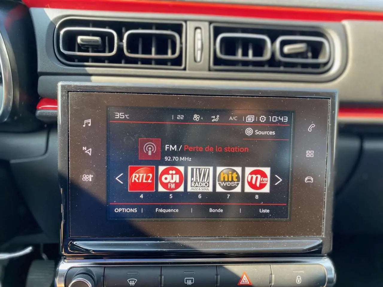 Tablette tactile 7 pouces du système CITROËN Connect Nav dans l'habitacle de la C3, avec bandeau orange visible en arrière-plan.