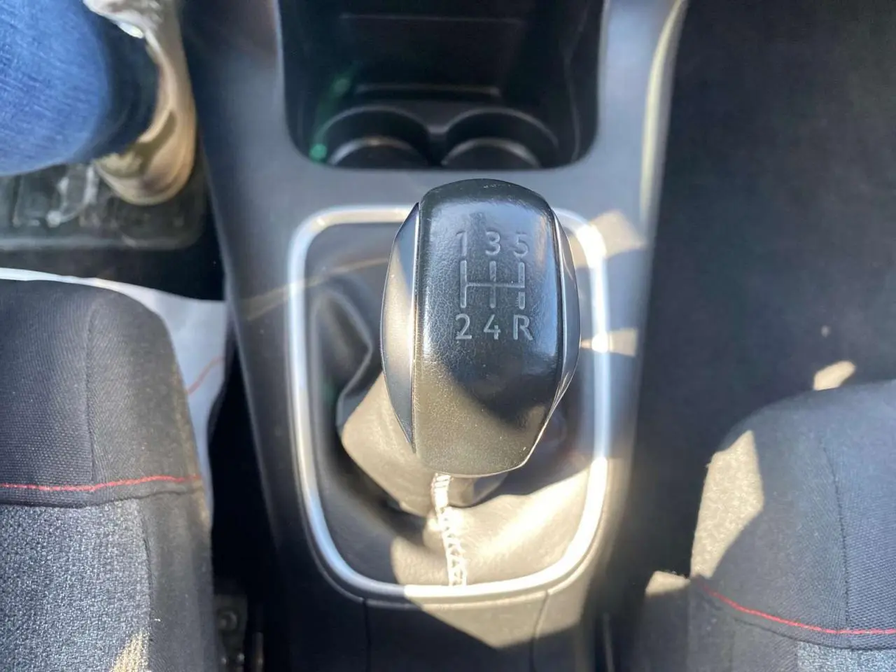 Le levier de vitesses manuel noir de la Citroën C3 2018, entre les sièges avant en tissu noir.