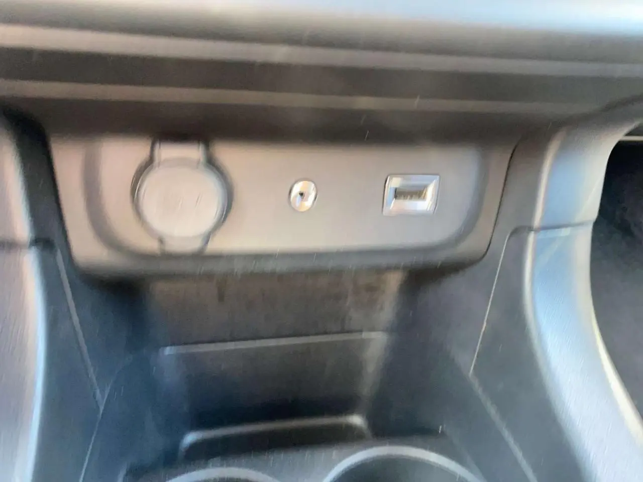 Gros plan sur la prise USB et allume-cigare dans l'habitacle noir d'une Citroën C3 2018.