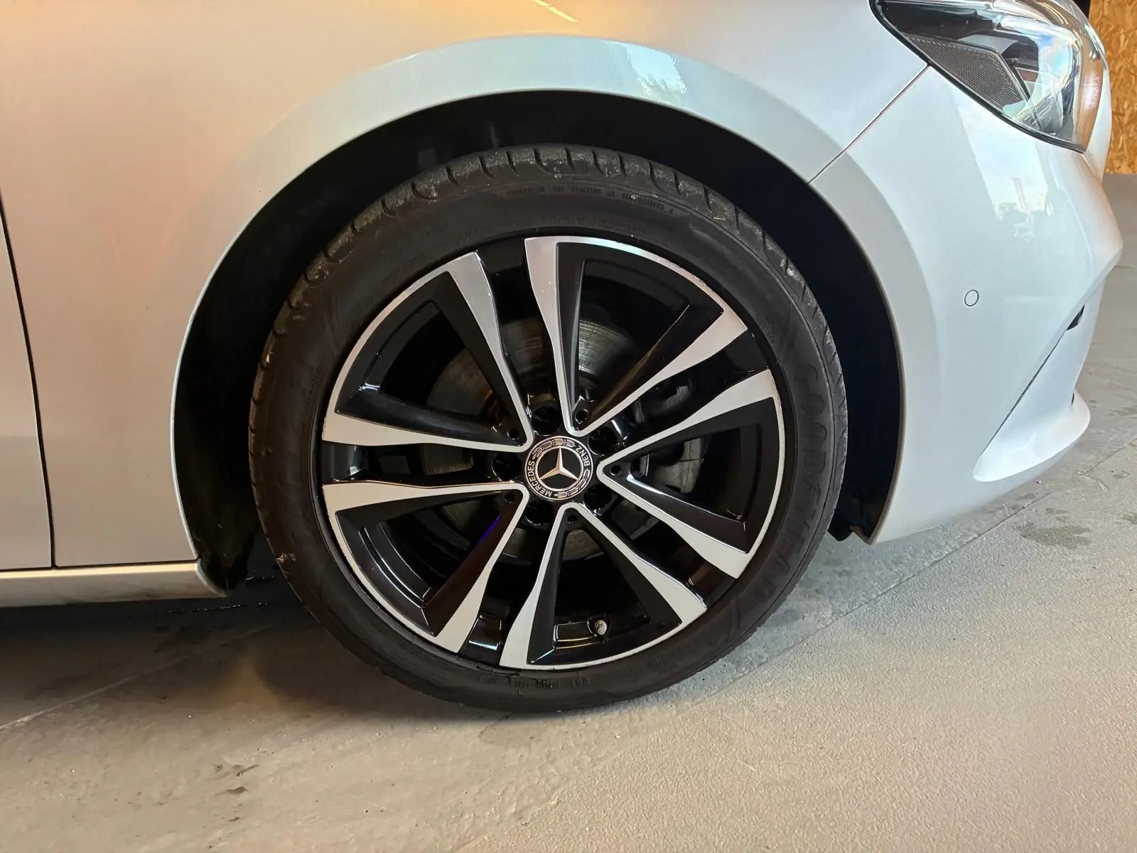 Gros plan sur la roue avant droite gris clair d'une Mercedes Classe B 200D Progressive Line avec jante alliage noir et argent.