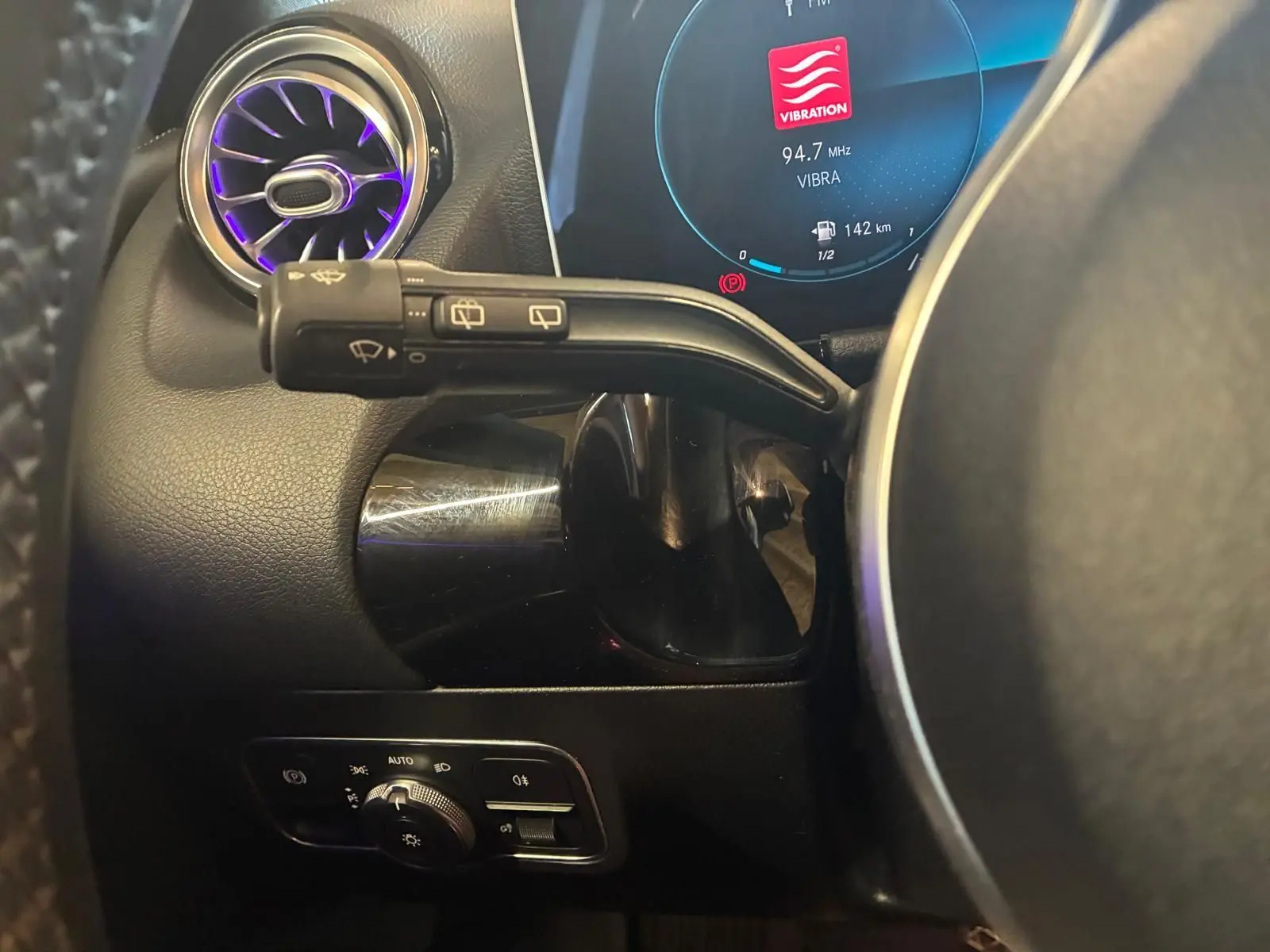 Détail intérieur côté gauche du volant d’une Mercedes Classe B 200D gris, avec commandes d’éclairage et écran digital.