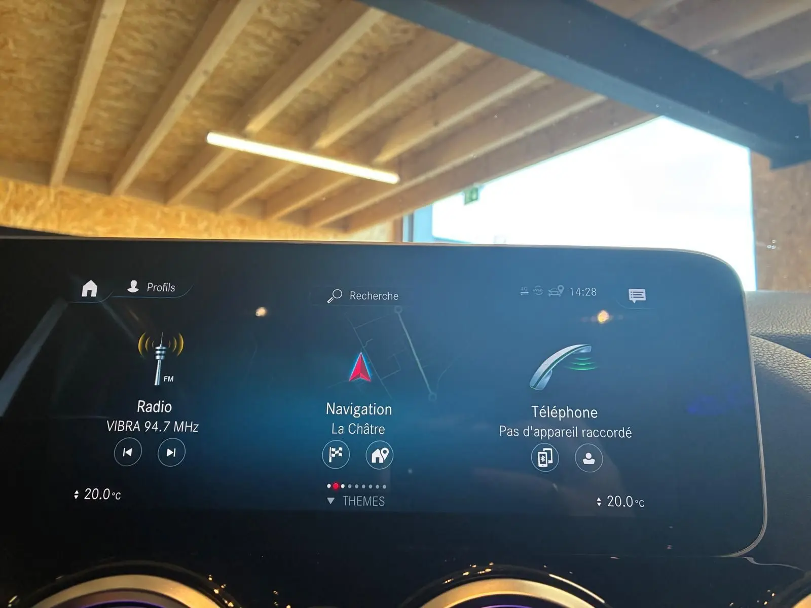 Écran central tactile de la Mercedes Classe B 200D gris, affichant radio, navigation et téléphone, intérieur sous lumière naturelle.
