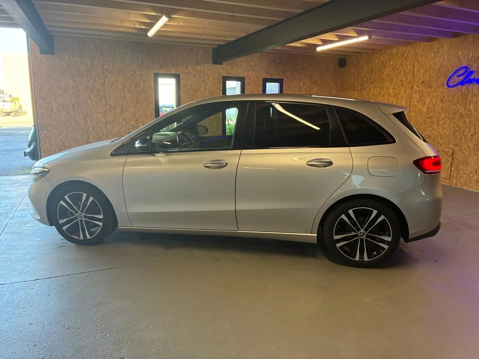 Vue de profil côté gauche d'une Mercedes Classe B 200D Progressive Line gris métallisé, avec jantes alliage noires et toit lisse.