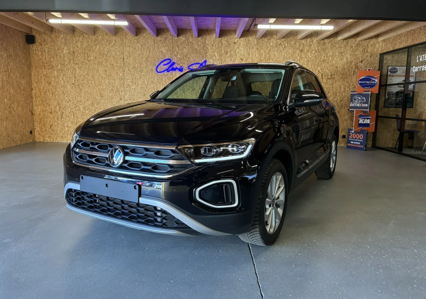 Volkswagen T-Roc noir en 3/4 avant droit, mettant en valeur sa calandre chromée et ses phares LED distinctifs.
