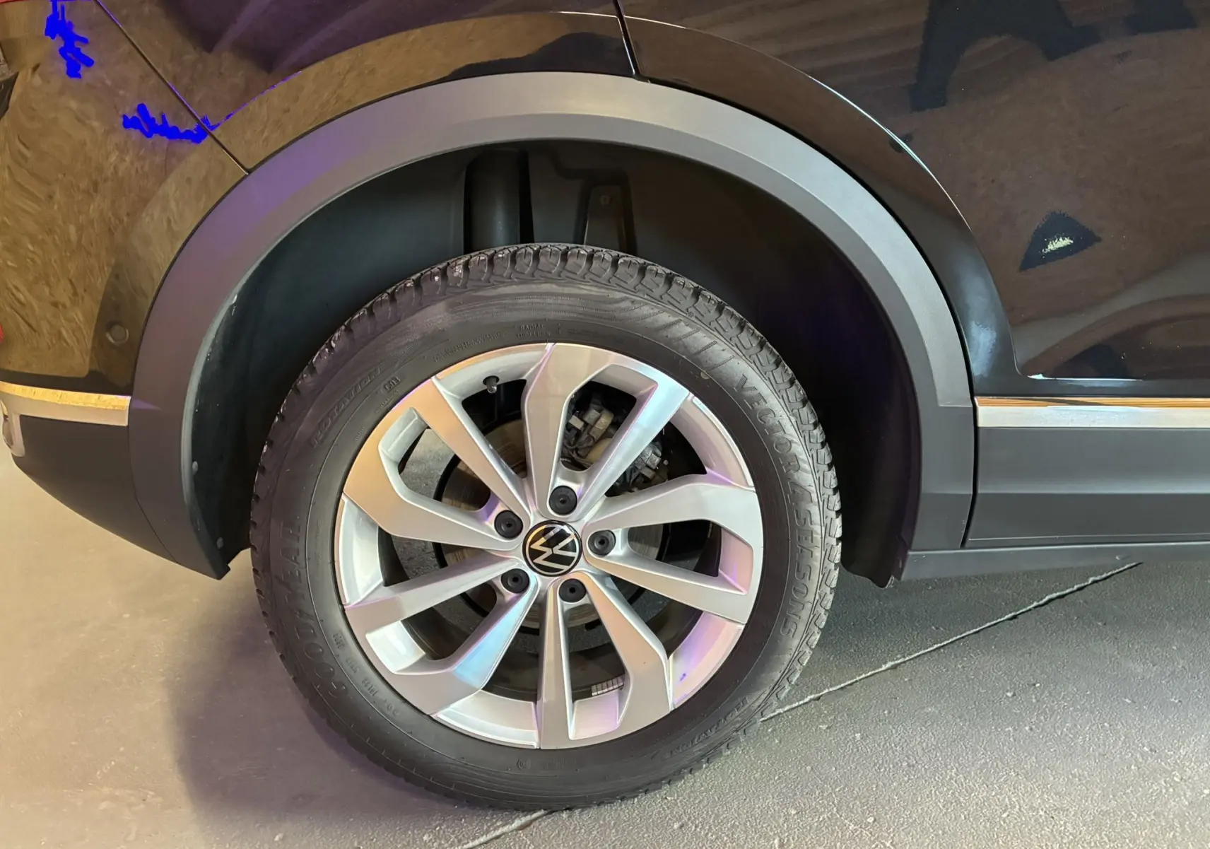 Gros plan sur la roue avant droite du Volkswagen T-Roc noir 2025, mettant en valeur la jante alliage et le pneu Goodyear.