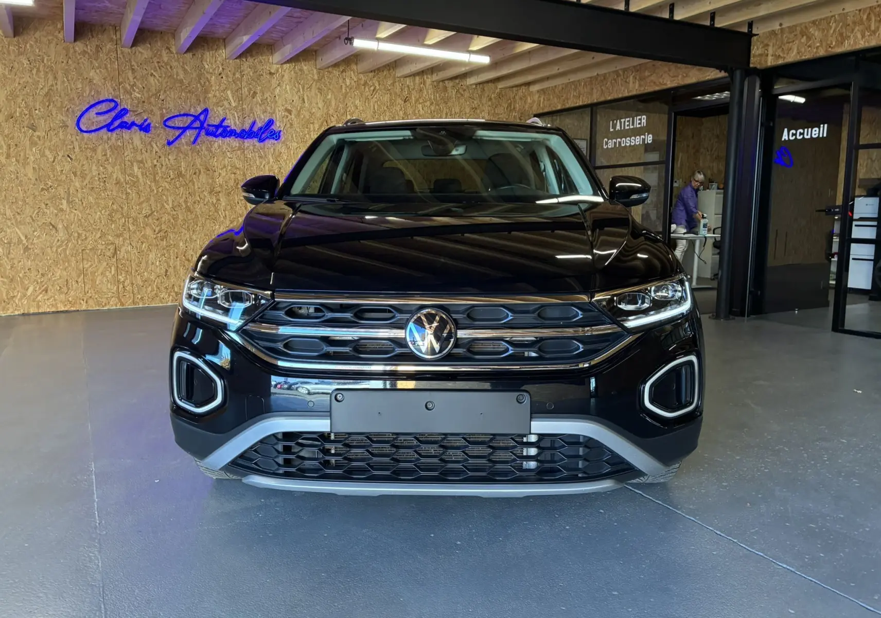 Vue de face du Volkswagen T-Roc noir 2025, mettant en valeur la calandre hexagonale et les phares LED distinctifs.