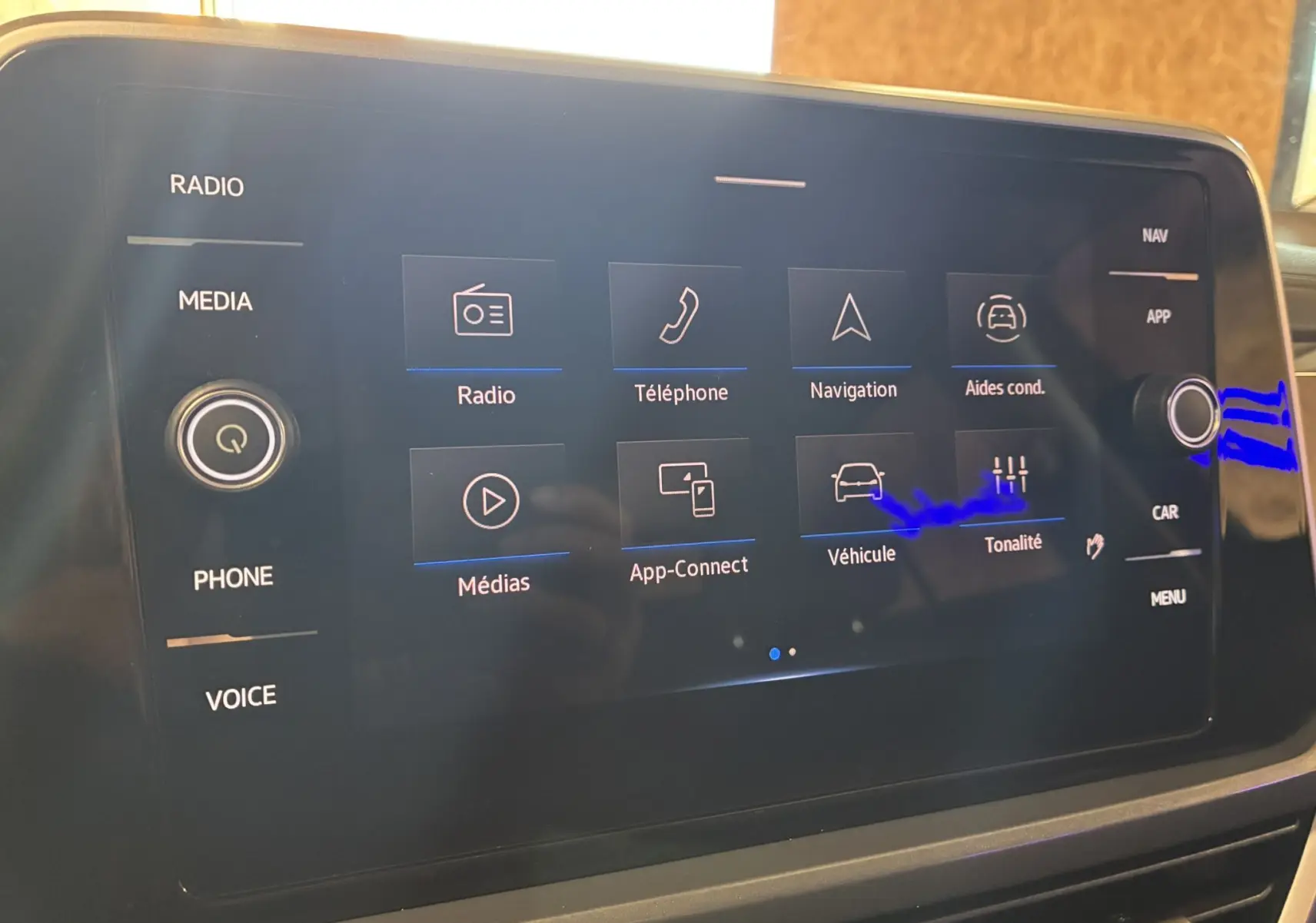 Écran tactile central du Volkswagen T-Roc noir 2025 affichant les options radio, téléphone, navigation et aides à la conduite.