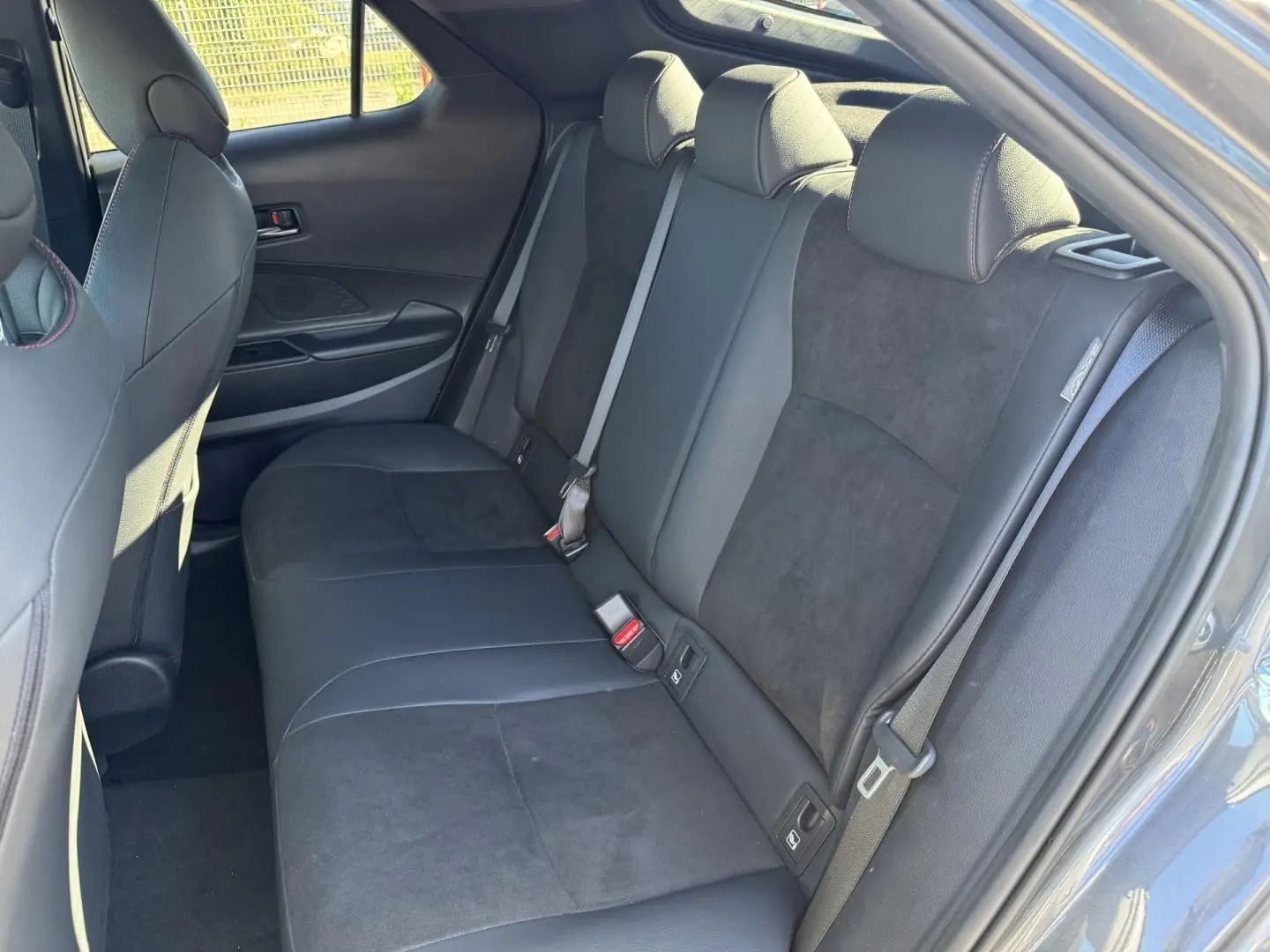 Vue intérieure côté droit sur la banquette arrière en suédine noire du Toyota C-HR 2.0 Hybride 2025.