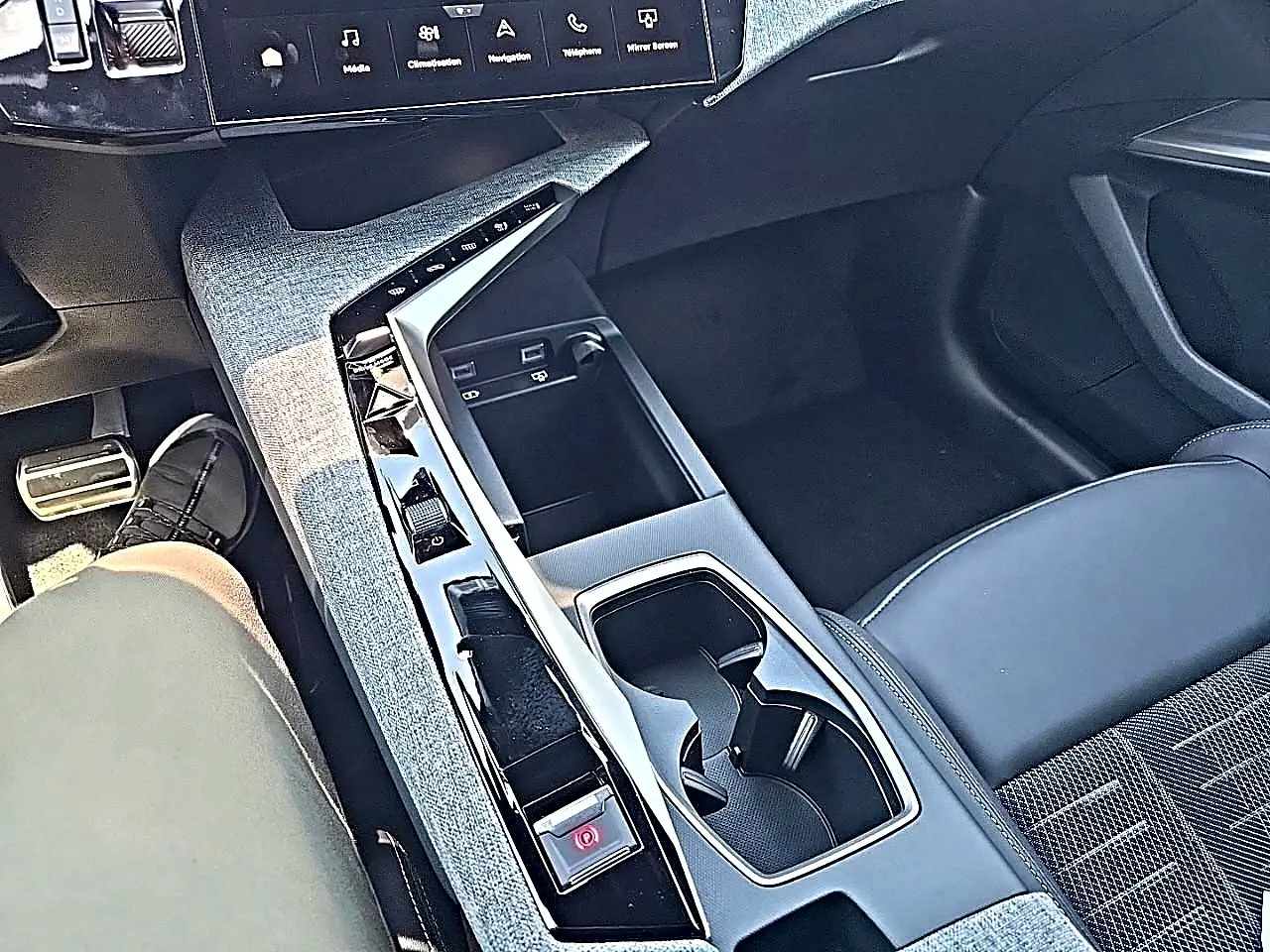 Vue plongeante sur la console centrale noire et grise du Peugeot 3008 1.2 hybrid 145 GT, avec sièges tissu et cuir.