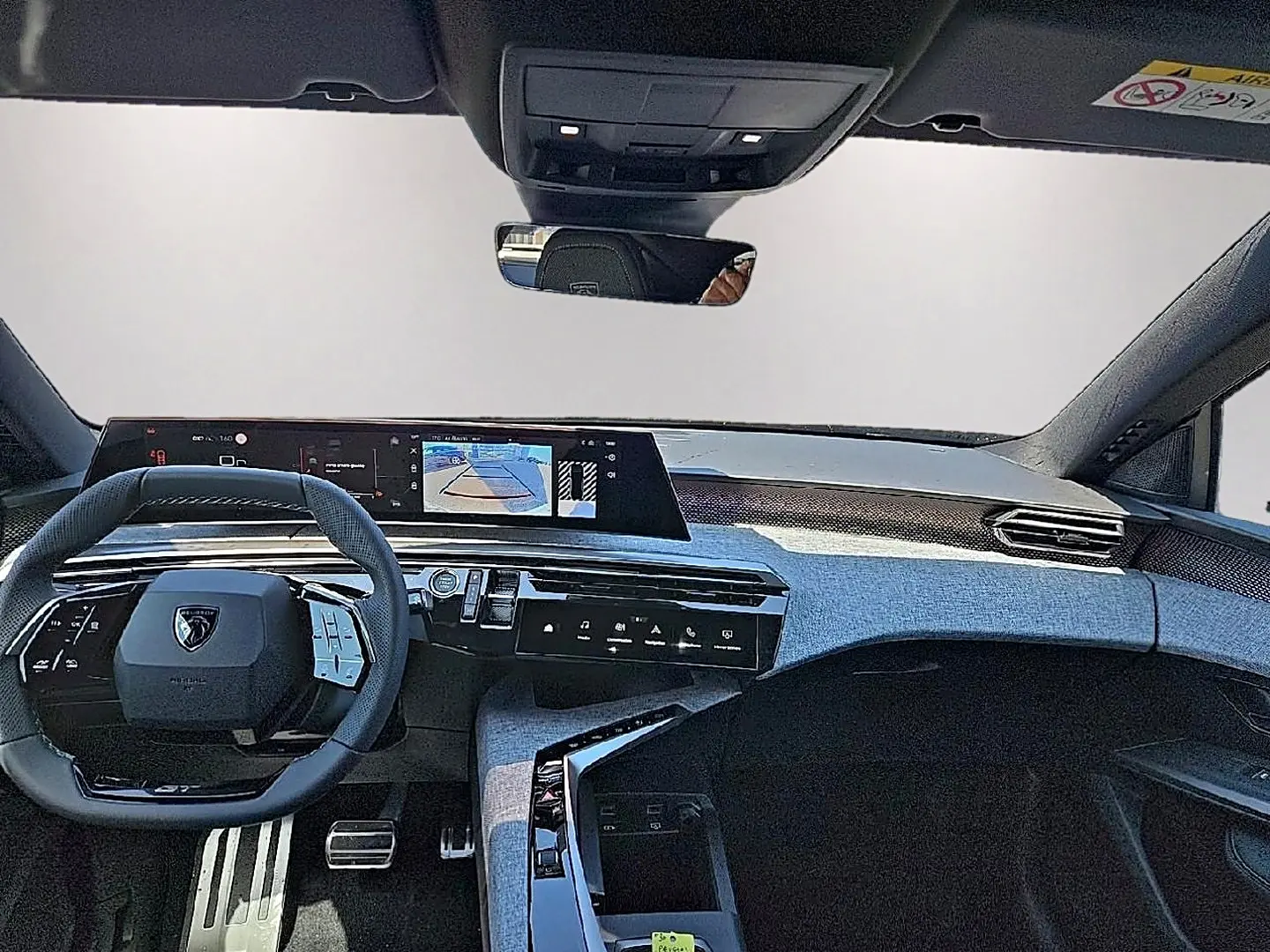 Vue intérieure avant du Peugeot 3008 noir 2026, mettant en valeur le tableau de bord numérique et le volant multifonction cuir.