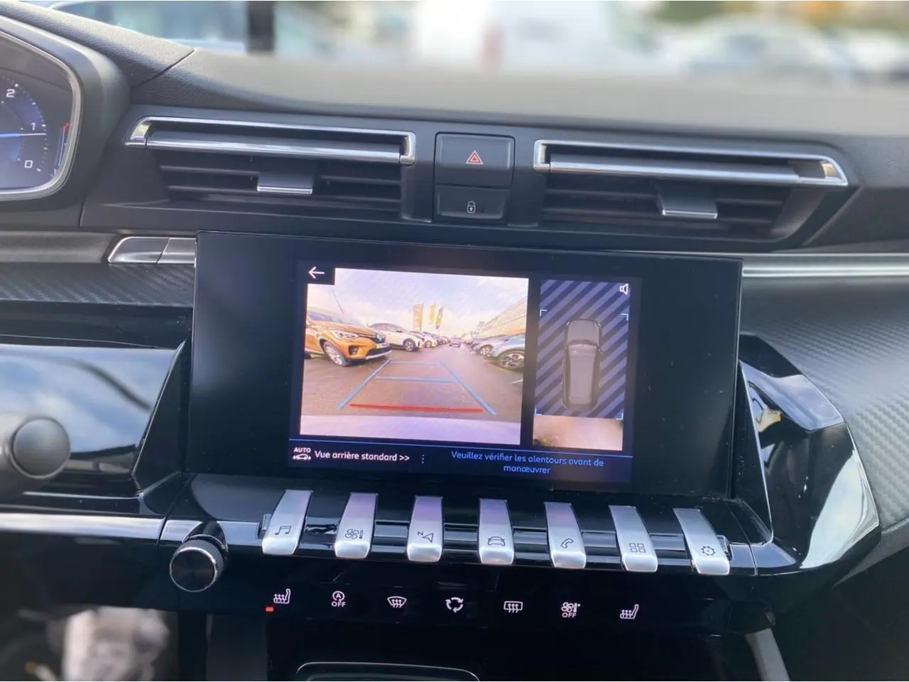 Vue rapprochée de l'écran tactile central affichant la caméra de recul et l'aide au stationnement du Peugeot 508 SW gris Artense.