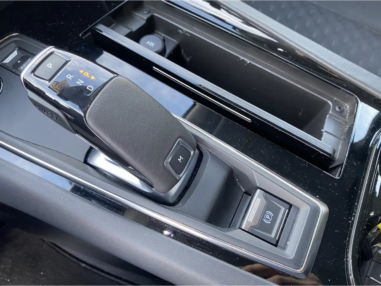 Gros plan sur la commande de boîte automatique et frein de parking électrique dans la console centrale d'une Peugeot 508 SW gris Artense 2021.