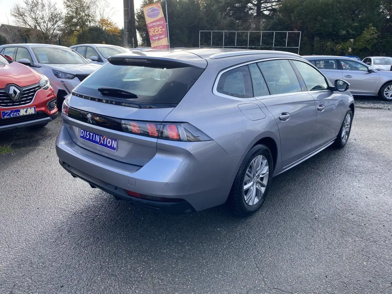 Peugeot 508 SW gris Artense vue 3/4 arrière droit, break diesel avec feux arrière à griffes distinctifs.