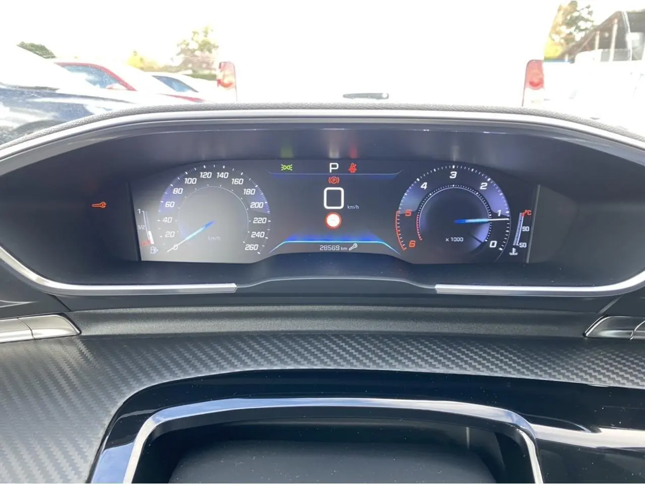 Tableau de bord numérique du Peugeot 508 SW gris Artense, affichant vitesse et compte-tours en vue frontale.