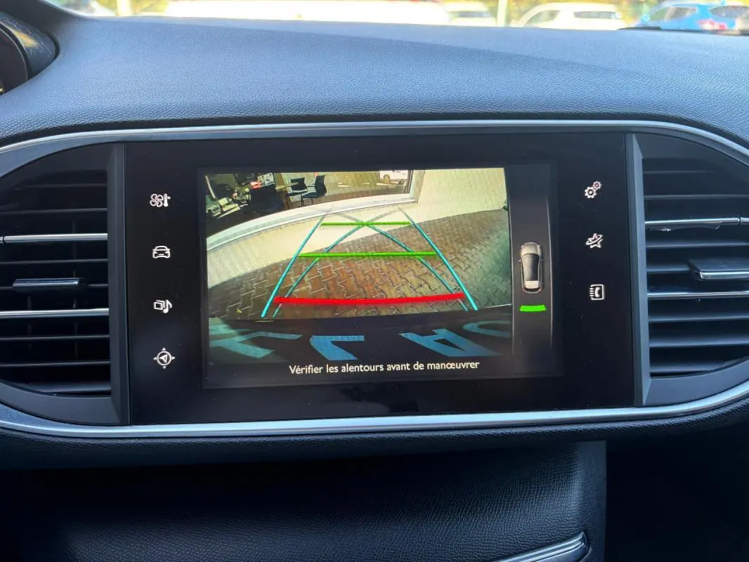 Écran central de la Peugeot 308 Active 2014 noir montrant la caméra de recul avec lignes de guidage colorées.