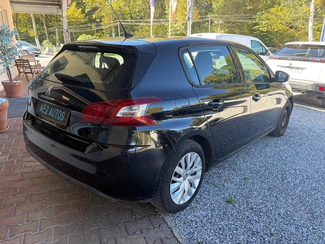 Peugeot 308 Active noire vue en 3/4 arrière droit, avec jantes alliage et plaque AE2 AUTOS visible.