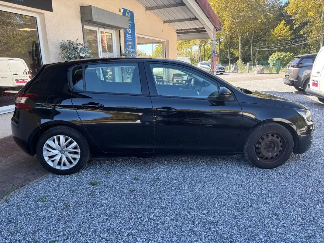 Peugeot 308 Active noire vue de profil côté gauche, avec jante alliage arrière et roue acier avant.